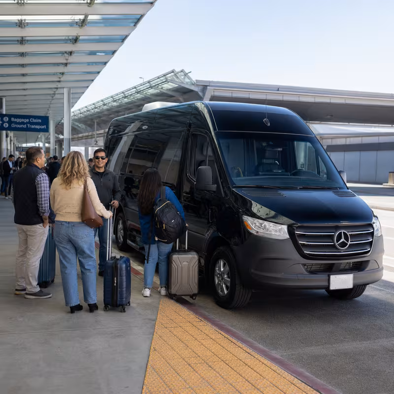 Group boarding a white charter bus for Airport Transportation transportation in Santa Clarita