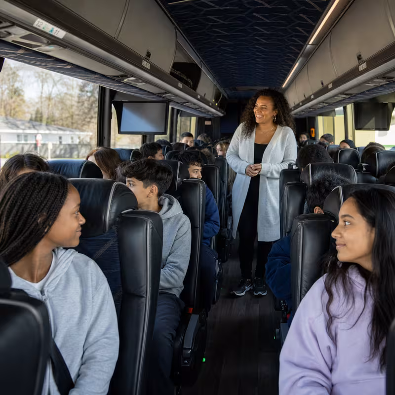 Group boarding a white charter bus for School Transportation transportation in Santa Clarita