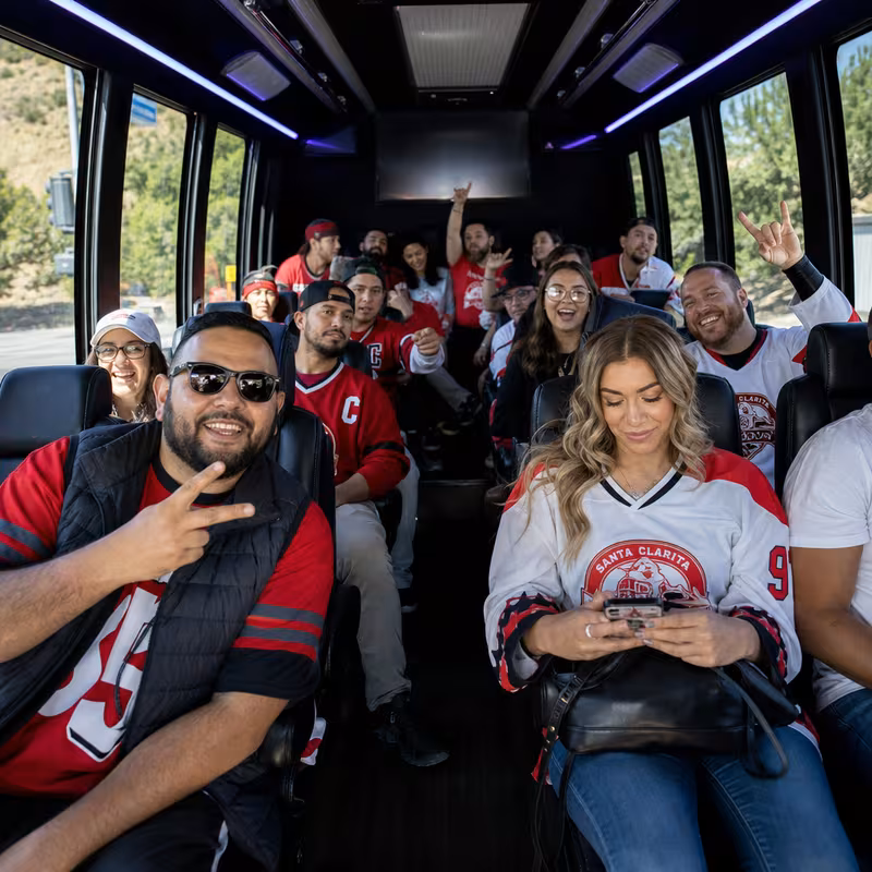 Group boarding a white charter bus for Sporting Event Transportation transportation in Santa Clarita